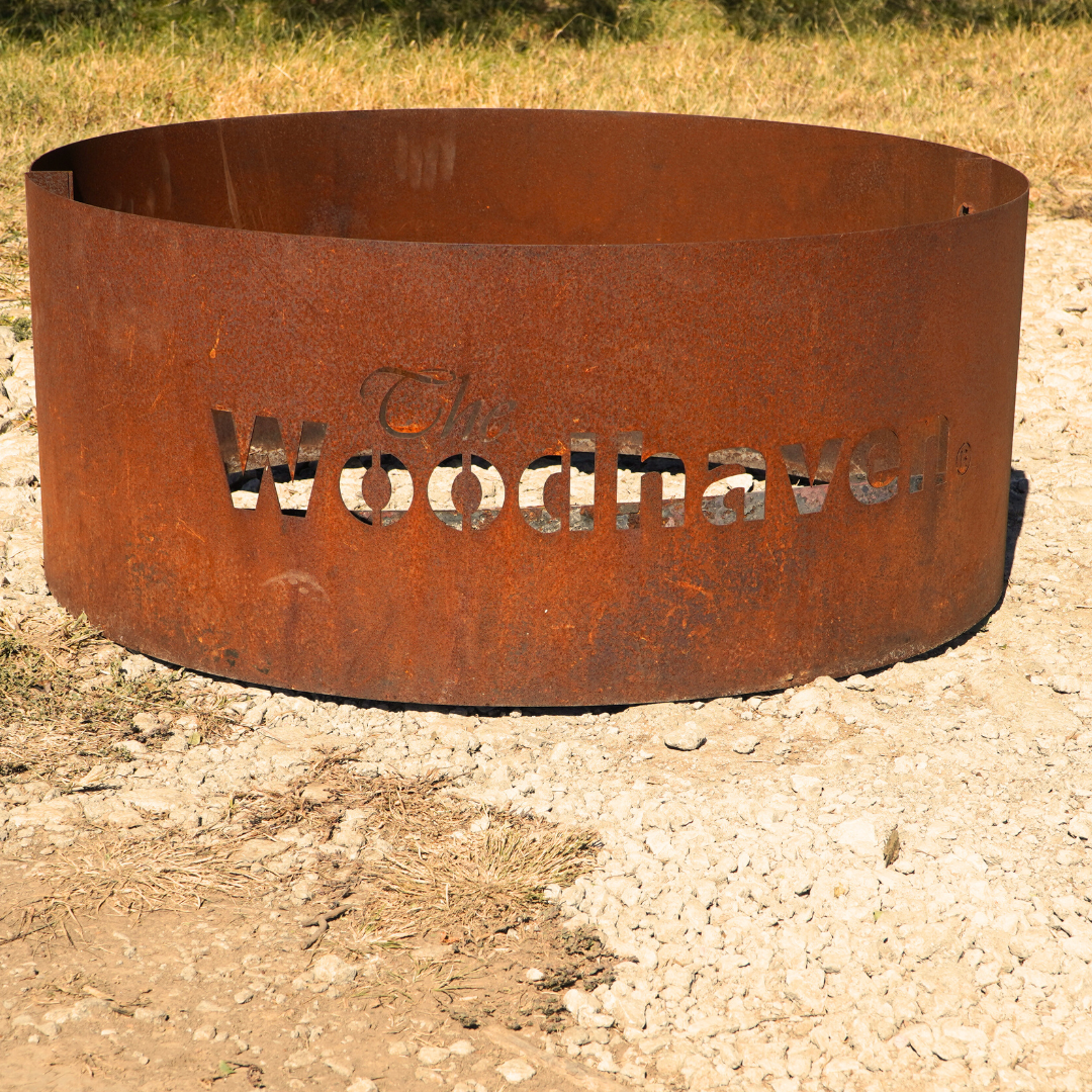 Woodhaven Portable Steel Fire Pit with stainless steel cooking grate, shown outdoors