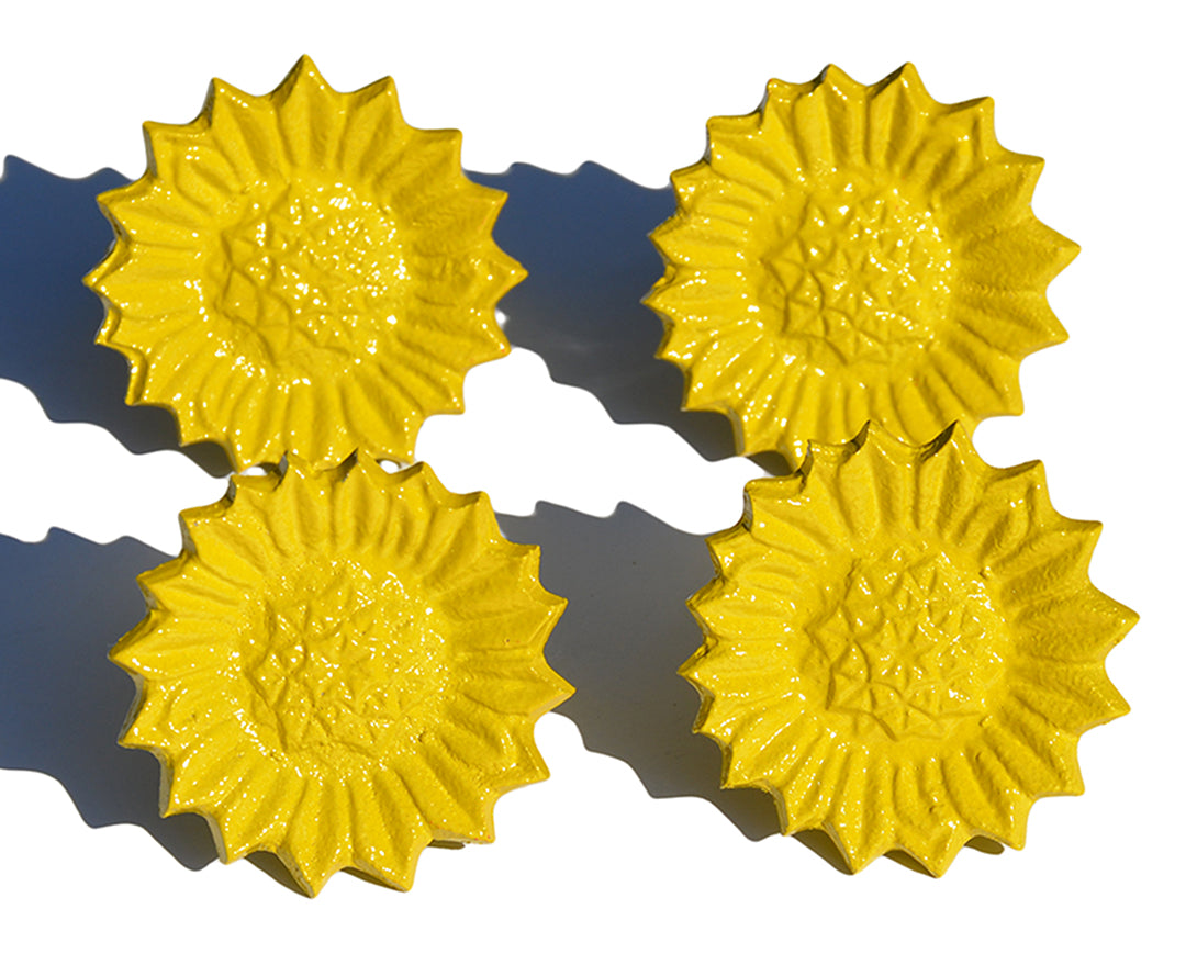 Set of four Vibhsa sunflower yellow napkin rings arranged on a white dining table