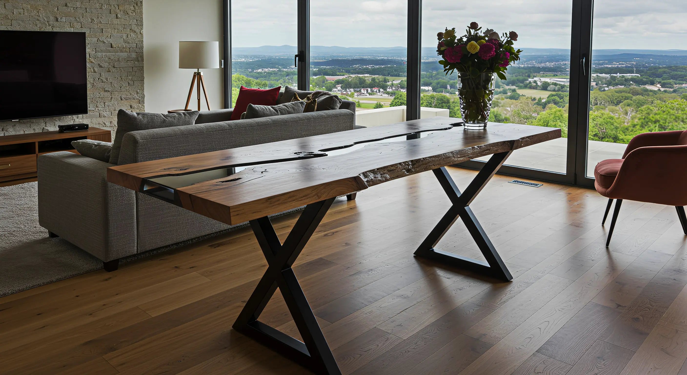 resin console table inside a luxury cabin with floor to ceiling windows and a view of the mountains.  The epoxy console table has black resin, walnut wood, and x metal legs.