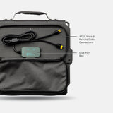 Black carrying case with a gray textured panel containing a black USB port box and XT60 male and female cable connectors with yellow tips, shown from above.