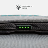 Close-up of a gray textured device with a hexagonal pattern showing a sun quality meter indicator with four green LED lights.