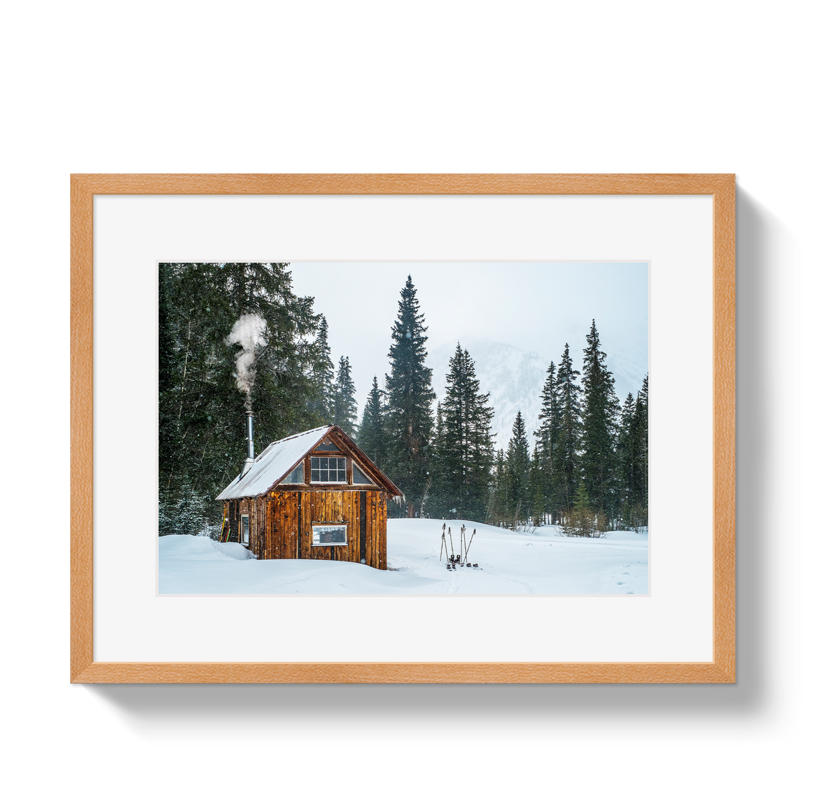 Rustic wooden cabin with smoke rising from the chimney, surrounded by snow and tall evergreen trees under a pale sky.