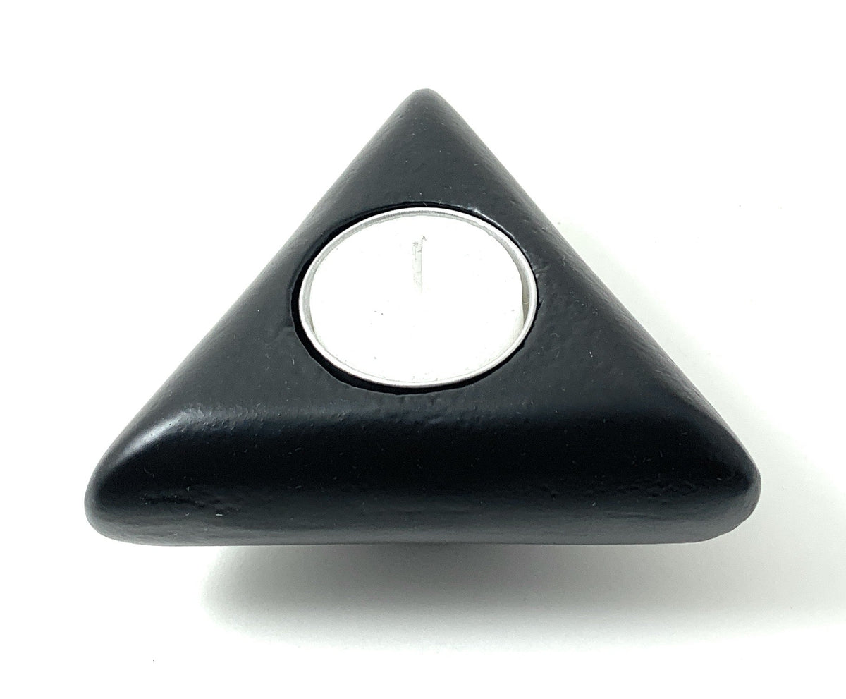 Black triangular candle holder with smooth rounded corners holding a small white tealight candle, shown from above on a white background.