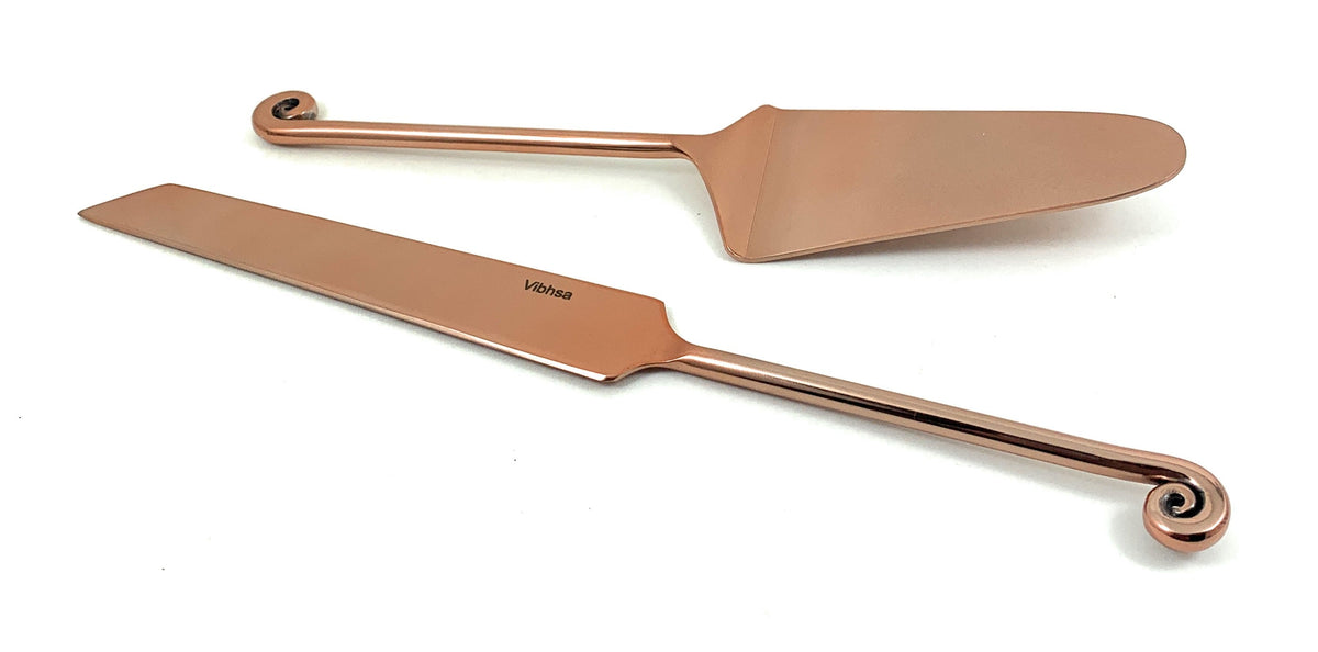 Copper-finished cake server and knife with treble clef handle details, shown on a white background.