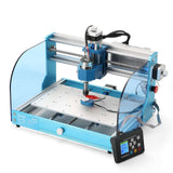 Blue desktop CNC router with transparent side panels and aluminum frame, featuring a central spindle over a perforated work surface and a digital control panel.