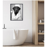 Framed black and white photo of a black Labrador wrapped in a white towel hanging above a white freestanding bathtub in a minimalist bathroom with wood shelves.