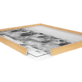 Close-up side view of a wooden frame with glass partially removed, containing a black and white print depicting a group of Highland cows in a grassy landscape.