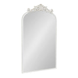 Tall rectangular mirror with an arched top and ornate carved floral detail in white along the top edge against a white background.