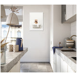 Modern white kitchen with concrete countertops, gray tile floor, hanging pendant lights, and a framed canvas of a golden retriever in a white bathtub on the far wall.