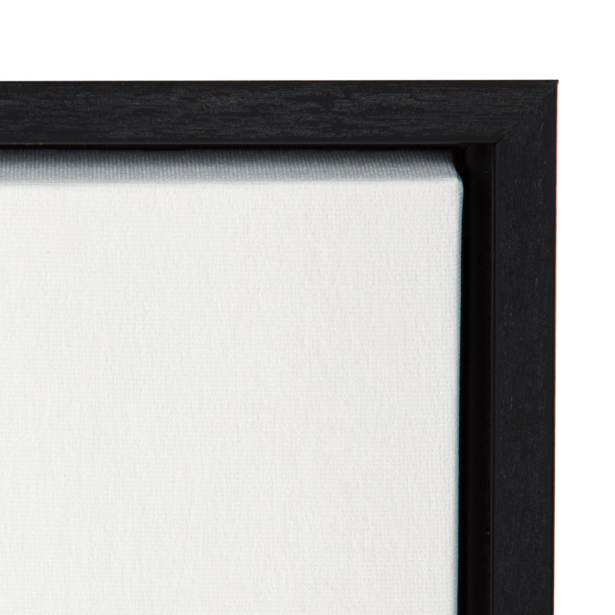 Close-up of a black wooden frame surrounding a white stretched canvas corner with visible texture and fabric weave.