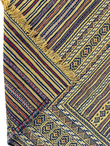 Close-up of a hand-woven Maliki wool kilim rug showing intricate geometric patterns and stripes in mustard yellow, navy, red, and cream with fringed edges.