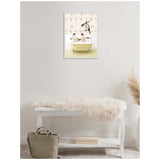 Framed canvas art above white bench with fur throw, depicting penguins in a vintage yellow clawfoot bathtub against floral wallpaper.