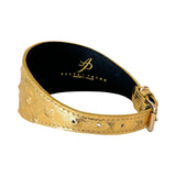 Gold leather collar with embossed studs and a gold buckle, shown in a curved position revealing a black interior with a gold logo imprint.