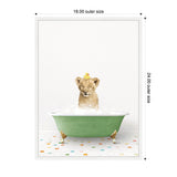 Young lion cub sitting in a green clawfoot bathtub filled with bubbles, with a yellow rubber duck on its head, on a colorful tiled floor against a white background.