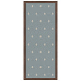 Rectangular wall pinboard with muted blue fabric and evenly spaced small white botanical block print motifs, framed in dark wood.