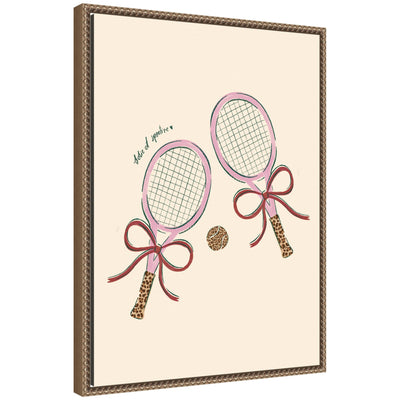 Framed canvas wall art print showing two pink tennis rackets with leopard patterned grips and bows alongside a pink tennis ball on a neutral background, set in a dark gold ornate vintage frame.