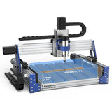 Compact desktop CNC router with aluminum frame, black motor housings, and blue accents, featuring a spindle and work area labeled with dimensions in millimeters and inches.