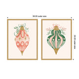 Two framed holiday ornament illustrations: left is pink with gold and white detailing and green foliage accent, right is green with pink stripes, gold top and bottom accents, both set on beige backgrounds.