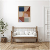 Modern bohemian abstract geometric wall art with navy, beige, rust, and lavender shapes in a natural wood frame above a wooden bench with white cushions in a minimalist room.