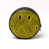 Round wash bag with yellow and black zig-zag pattern forming a large smiley face, featuring oval eyes and a curved mouth, against a white background.