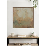Square abstract wall art in muted sage green and soft beige tones with textured brushstrokes, framed in dark wood, hanging above a wood and metal console table with books, mug, vase, and beads.