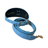 Light blue textured pet collar and matching leash set with silver buckle and gold clasp, shown coiled against a white background.