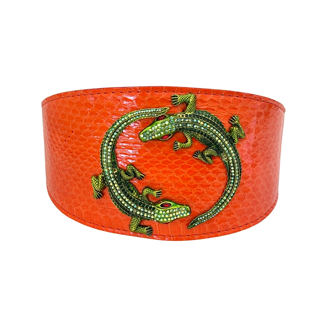 Curved orange snake-patterned collar adorned with two green rhinestone alligator decorations facing each other in a circular formation