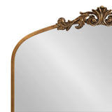 Arched mirror with ornate gold leaf decorative crest and a slim gold frame, featuring elegant scroll and leaf motifs at the top center.