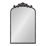 Rectangular wall mirror with a rounded arch top and ornate black carved floral design at the crown, featuring a slim black frame.