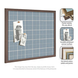 Light blue fabric pinboard with white grid lines inside a medium brown wood frame, displaying two black-and-white photos pinned with wooden clips.