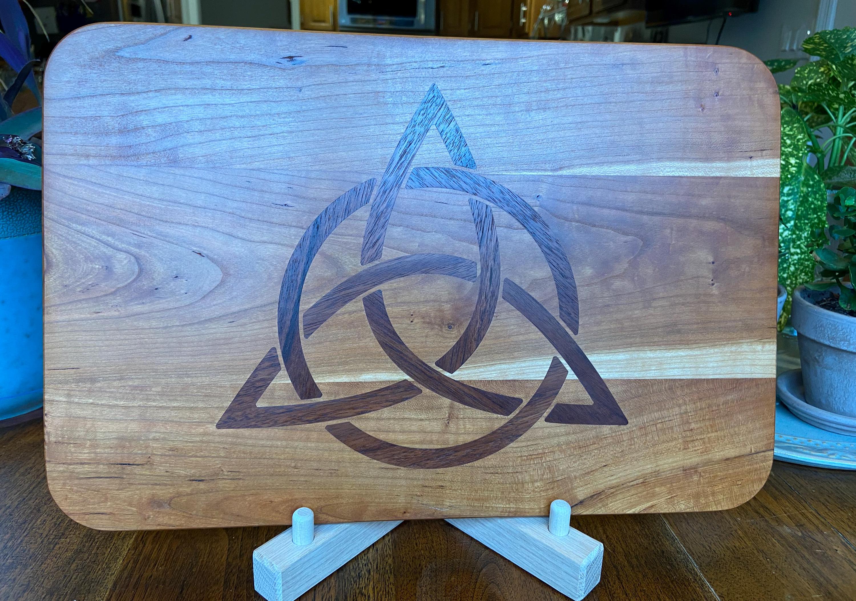 Cherry wood charcuterie board with Celtic Knot triquetra inlay made of Peruvian walnut