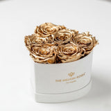 Beige suede box holding 6 gold roses shaped in a heart