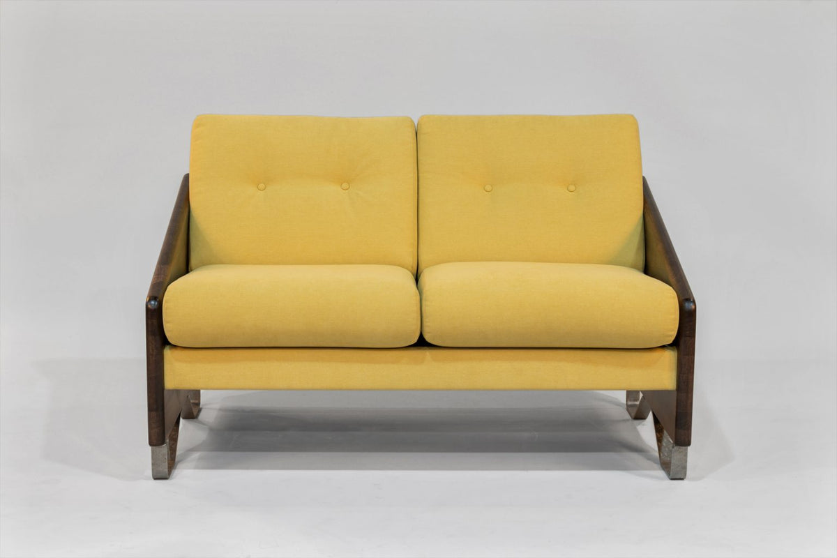 Two-seat loveseat with mustard yellow cushions and dark zebra-patterned wooden arms, featuring a compact modern design with metal-tipped legs.