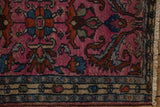 Section of a vintage Borchalou rug mat featuring a pink field with blue and rust floral motifs and a dark beige border accented by small geometric shapes.