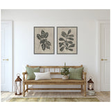 Two-piece framed canvas set with black botanical sketches of holly leaves and berries on textured beige background, hanging above a wooden bench with green and white pillows.
