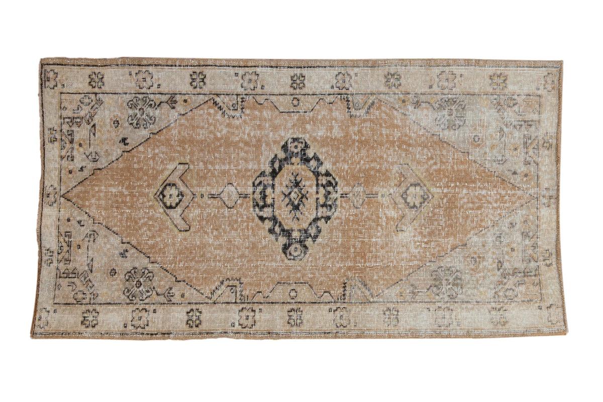 Vintage distressed Oushak rug runner in dusty gold, beige, and navy shades with minor medallion detail