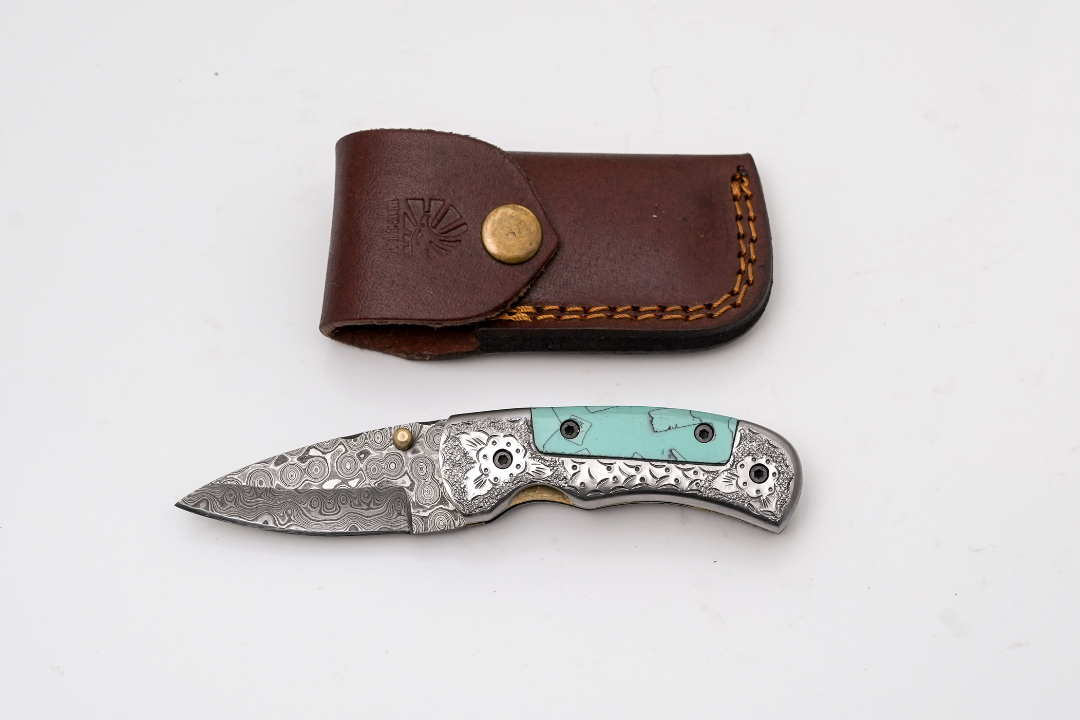 Hand-Forged Damascus Folder with turquoise handle and engraved steel bolster showing intricate floral scrollwork