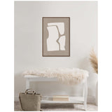 Abstract framed canvas art with white organic shapes on a taupe background, hanging above a white bench draped with a fluffy cream throw in a minimalist room.