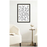 Minimalist wall art print featuring black outlined abstract wine glasses on white background in a black and gold frame, displayed above a small brass side table between two white upholstered chairs.
