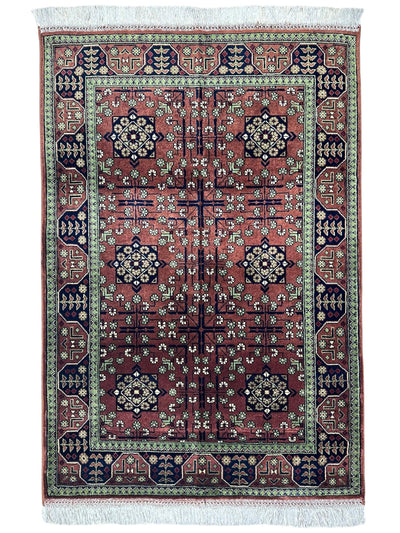 Hand-knotted Bukharayi rug in brown, deep red, ivory, and gold tones laid on floor