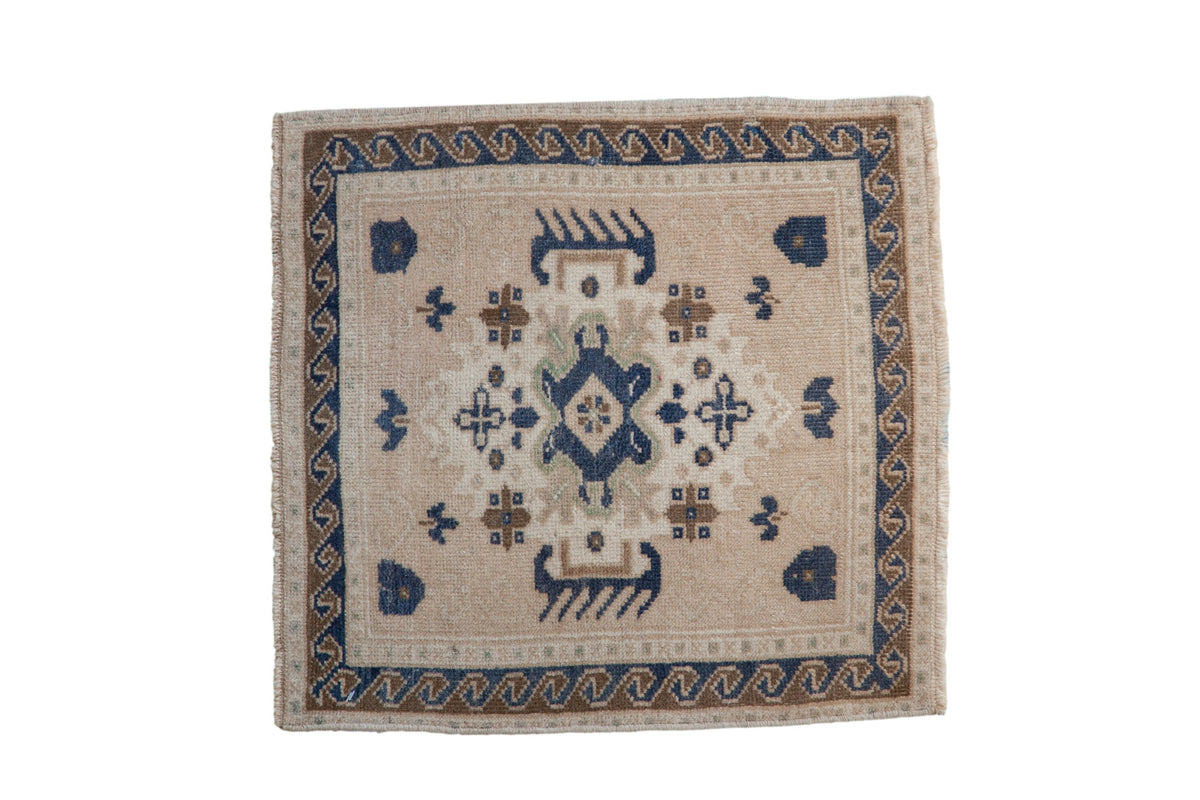 Vintage distressed Oushak square rug mat with oversized medallion and mellow colors of cream, beige, dusty navy blue, and sand.