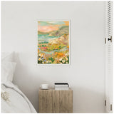 Framed canvas painting of a colorful landscape with hills, a body of water, and wildflowers in orange, pink, green, and blue tones hanging on a white wall above a wooden nightstand.