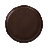 Round dark brown leather tray with a slightly irregular, organic edge and smooth, matte finish, shown from above on a white background.