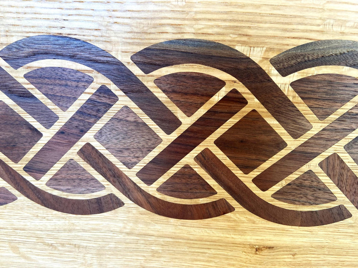 White Oak charcuterie board featuring a complex Celtic knot inlay made of Peruvian Walnut