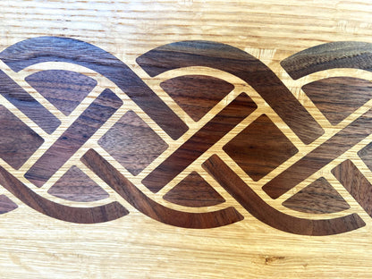 White Oak charcuterie board featuring a complex Celtic knot inlay made of Peruvian Walnut