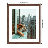 Framed photograph of a tiger leaning out from an open window with a view of Manhattan skyscrapers, including the Chrysler Building, in soft daylight.