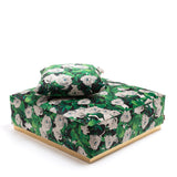 Square pouf with matching pillow featuring a green leaf and white rose pattern on all sides, resting on a light-colored flat base against a white background.