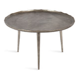 Round metal coffee table with a scalloped, slightly irregular edge and three slender, tapered legs in a textured pewter finish.