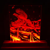 Red LED-illuminated acrylic panel featuring a line art of a flying pheasant over a barbed wire fence and a landscape with trees and stars at night.