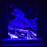 Etched acrylic panel lit with blue LED showing a flying pheasant above barbed wire fence posts under a starry night sky.